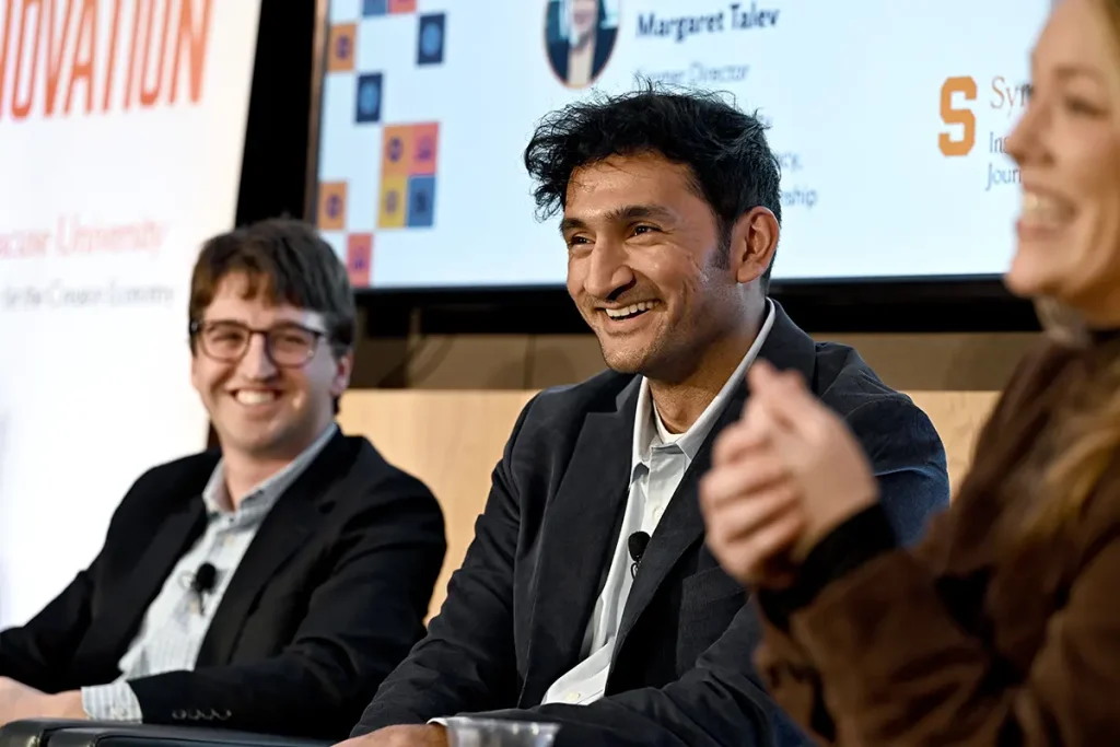 Panelists smiling during a stage discussion